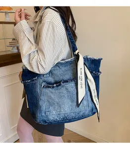 Détail des bords effilochés et patchwork de denim contrasté sur un grand sac cabas chic