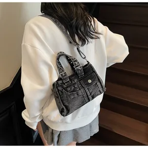 Détail du sac en jean noir délavé avec poches rétro Y2K et coutures blanches contrastées