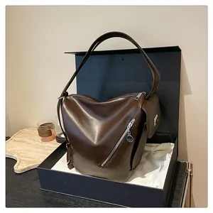 Close-up of a dark coffee soft leather tote bag featuring a decorative side zipper and pocket