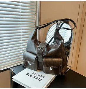 Detail of dark brown vintage faux leather shoulder bag with buckle strap and pockets