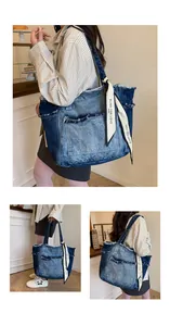 Détail d'un cabas en jean délavé avec franges et foulard en soie imprimé décoratif