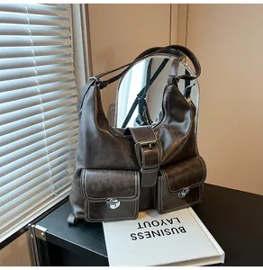 Detail of vintage brown tote bag showing contrast stitching and silver buckle pockets