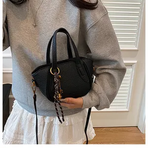 Detail der schwarzen Mini-Handtasche aus genarbtem Leder mit goldenen Beschlägen