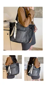 Détail du sac cabas en jean noir vieilli avec bords effilochés et foulard en soie décoratif