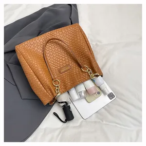 Spacious interior of brown woven tote bag showing daily essentials for commuting