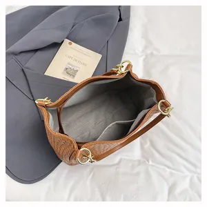 Top-down view of woven tote bag interior with grey lining and zippered pocket details