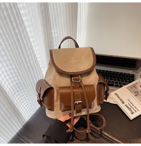 Detail of vintage canvas backpack with brown leather trim and multi-pocket design