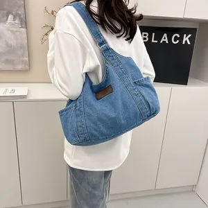 Light blue denim tote bag for women with leather tag shown on person in daily setting