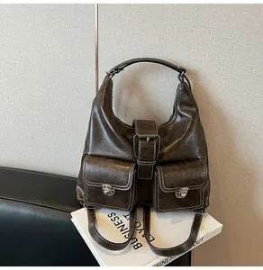 Detail view of coffee oil-wax leather texture and white stitching on a retro backpack