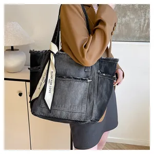 Détail du sac cabas en jean délavé avec bords usés et foulard décoratif blanc élégant