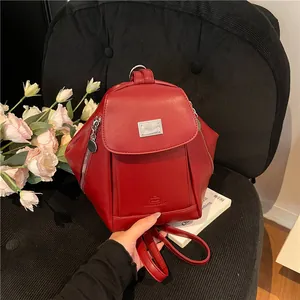Red geometric diamond pattern leather backpack with flap closure and metal plate detail