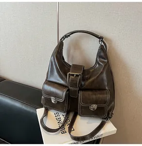 Detail of dark brown vintage faux leather bag with large silver buckles and double pockets