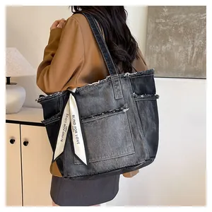 Gros plan du sac fourre-tout en denim délavé avec bords effilochés et foulard décoratif