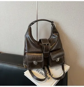 Detailed view of dark brown PU leather tote with silver buckles and vintage utility pockets