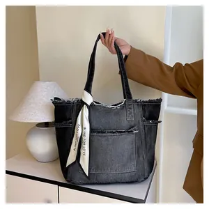 Détail du sac cabas en denim noir délavé vintage avec bords effilochés et foulard en soie