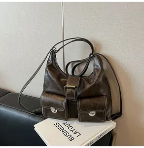 Detail of dark brown leather tote with white contrast stitching and metal turn-lock pockets
