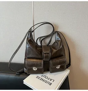 Close-up of vintage brown leather tote with white contrast stitching and silver buckles