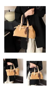 Detail view of vintage earthy faux suede tote bag with belt buckle and chocolate charm