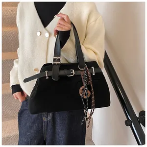 Detail of matte suede tote bag featuring silver buckle and woven rope accessory on strap