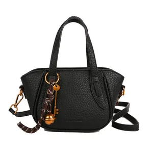 Schwarze Bucket Bag mit Lychee-Struktur, Goldanhänger und Umhängeriemen