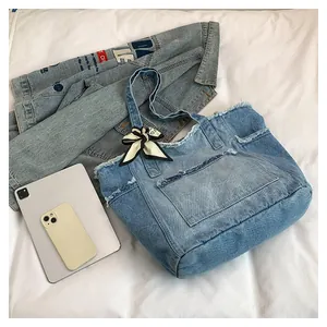 Détail des bords effilochés et du foulard décoratif sur le sac cabas en denim