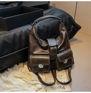 Detail of vintage brown leather bag showing contrast stitching and silver metal buckles