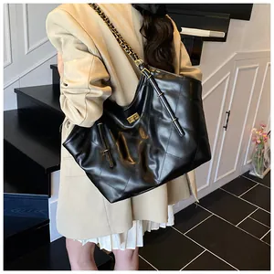 Classic black quilted tote bag with gold turn-lock and chain strap on a model