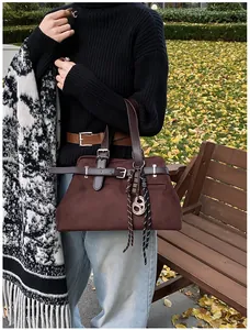 Close-up of retro dark brown matte tote bag with leather straps on a park bench