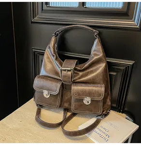 Detail of dark brown vintage faux leather shoulder bag with buckle and front pockets