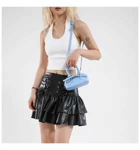Sac à main bleu clair en cuir grainé porté par un mannequin avec une tenue élégante