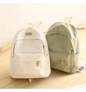 Detailed view of waterproof Oxford cloth backpacks in cream and sage green colors