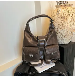 Detail of dark brown vintage faux leather handbag with silver twist locks and white stitching