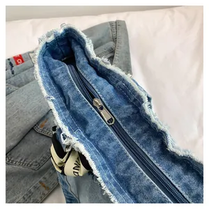 Détail du sac cabas en jean avec fermeture éclair et bords à franges