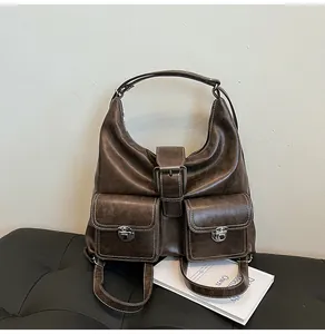 Detail of dark brown vintage faux leather shoulder bag with white contrast stitching