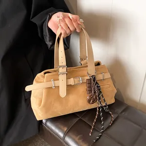 Women's vintage matte yellow tote bag with buckle straps and charm details in daily use