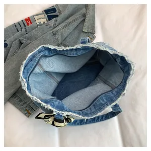 Détail de l'intérieur du grand sac cabas en denim avec bords effilochés et décor de foulard
