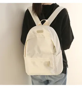 Rear view of a model wearing the cream-white waterproof Oxford cloth backpack