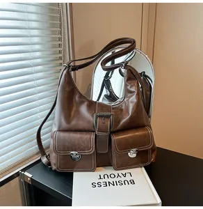 Detail of dark brown leather hobo bag with contrast stitching and dual front flap pockets