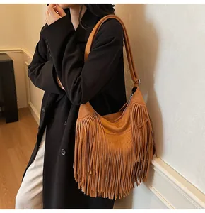 Close-up of brown suede hobo bag with long fringe tassels and adjustable strap