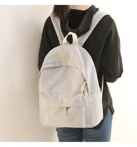 Detailed view of the water-resistant gray fabric and leather logo on the laptop backpack