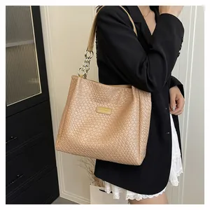 Detail of the woven texture and golden metal chain strap on this khaki tote bag
