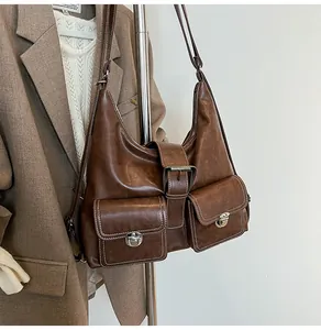 Detail of vintage brown leather hobo bag with dual pockets and silver buckles