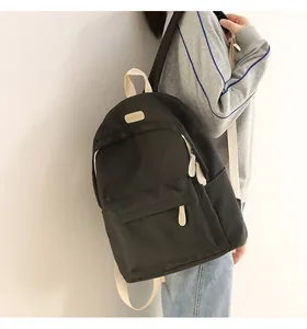 Detail of waterproof Oxford backpack with beige webbing straps and branded leather patch