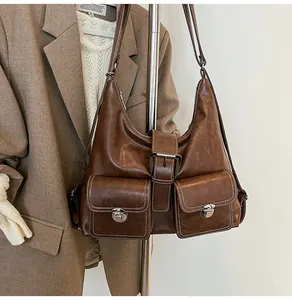 Detail of vintage brown shoulder bag featuring contrast stitching and silver turn-lock pockets
