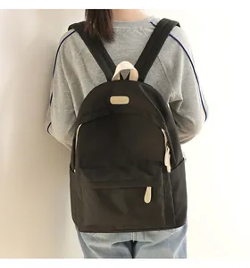 Rear view of a black waterproof oxford backpack on a model showing daily casual wear