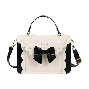 Chic black and white crossbody bag with large bow and elegant wavy scalloped edge