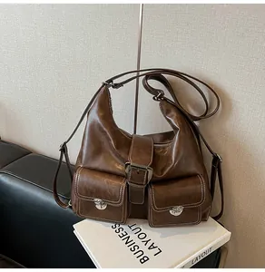 Macro shot of retro dark brown leather tote bag with dual front pockets and silver buckles