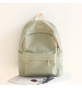 Detailed front view of light green waterproof Oxford fabric backpack with leather logo patch