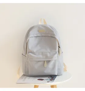 Detailed view of gray waterproof oxford backpack with front pocket and top handle