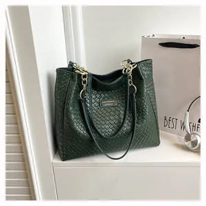 Detail view of dark green woven tote bag with gold chain and Fashionbag logo